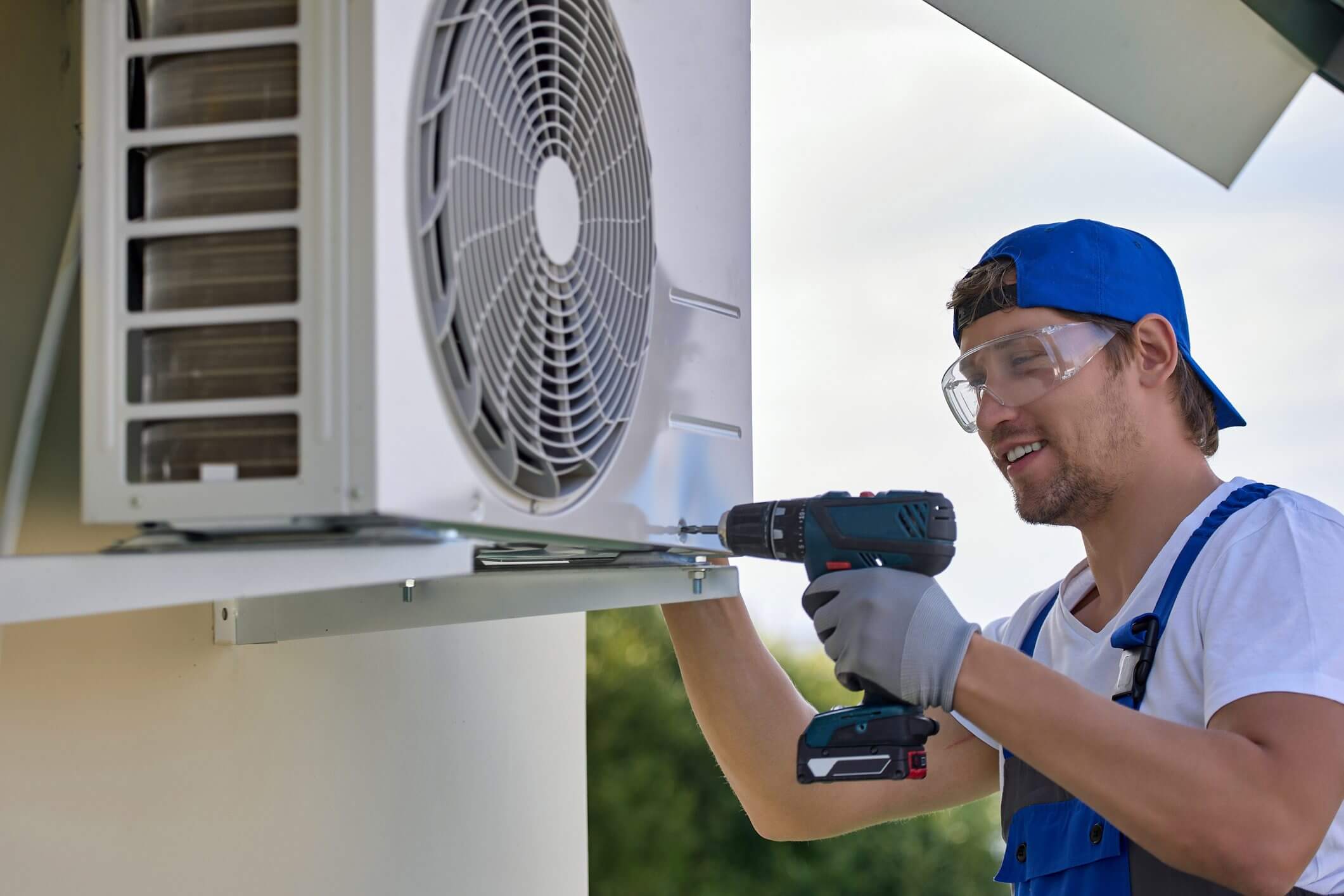 Technician installing outdoor air conditioning unit.