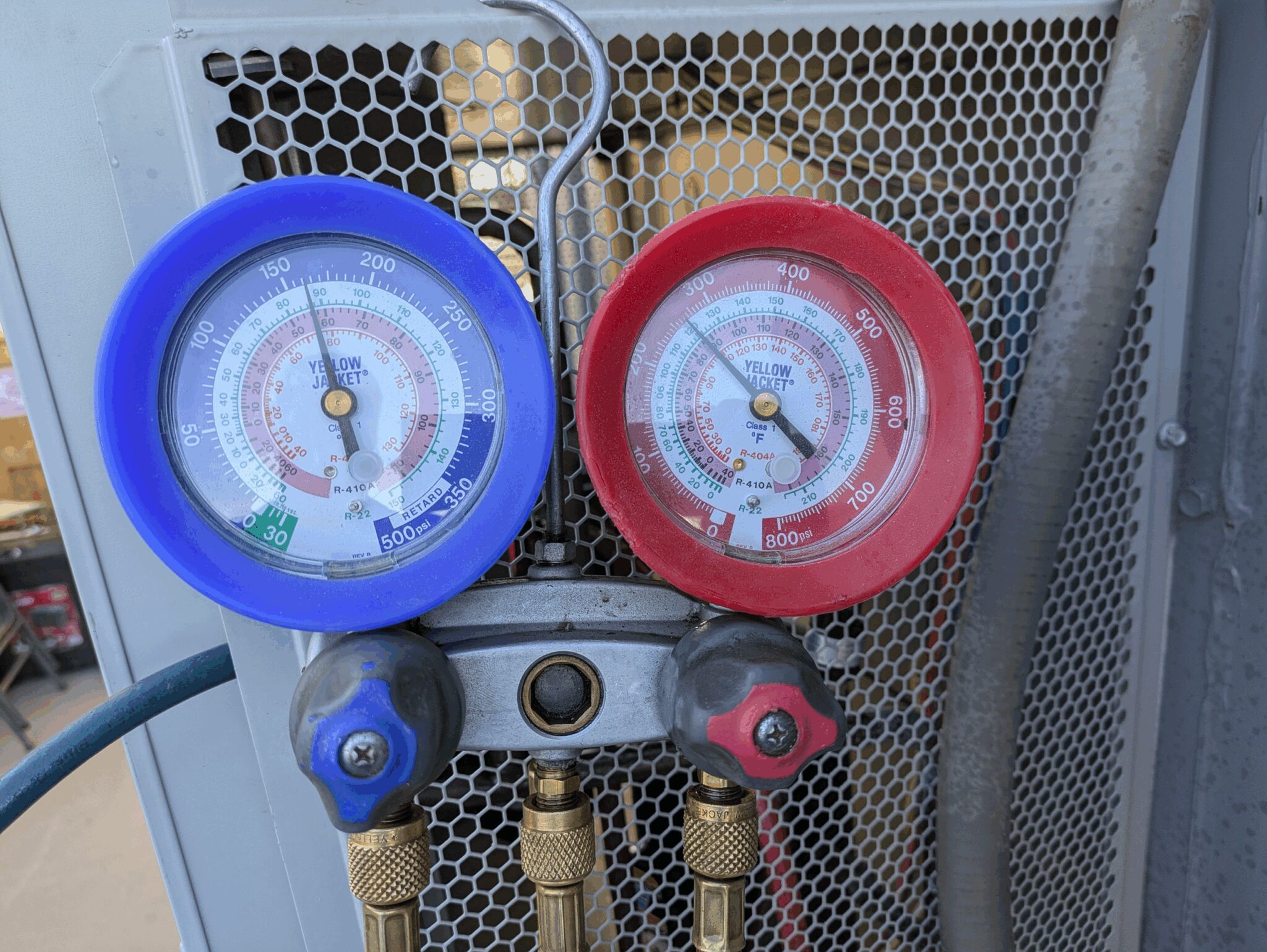 Manifold gauge set measuring pressure in HVAC system.